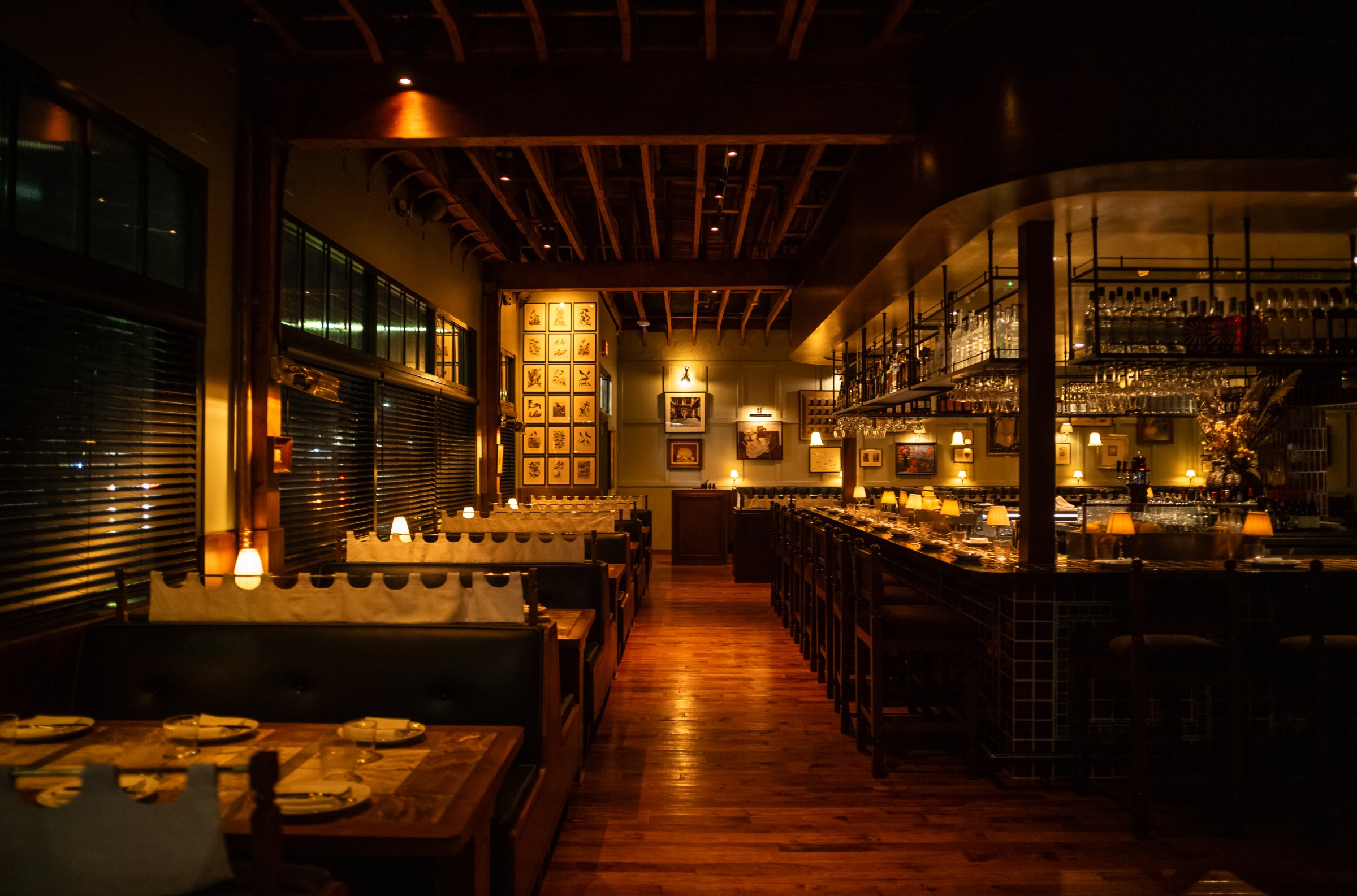 Dining room at Hermon’s at night, showing the edge of the bar and booths along the wall