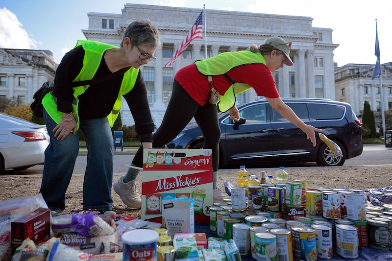 WASHINGTON, DC - OCTOBER 30: Volunteers organize donated beans, powered milk and other non-perishable items during a food drive in front of the U.S. Department of Agriculture on the National Mall during the 30th day of the federal government shutdown, October 30, 2025 in Washington, DC. Hosted by the Federal Unionists Network, Free DC and other activist organizations, the food drive and political rally brought together faith leaders, food bank workers, and furloughed federal employees who demanded that the Trump administration release $6 billion in emergency funds for the Supplemental Nutrition Assistance Program (SNAP), which helps 42 million people pay for groceries every month. (Photo by Chip Somodevilla/Getty Images)