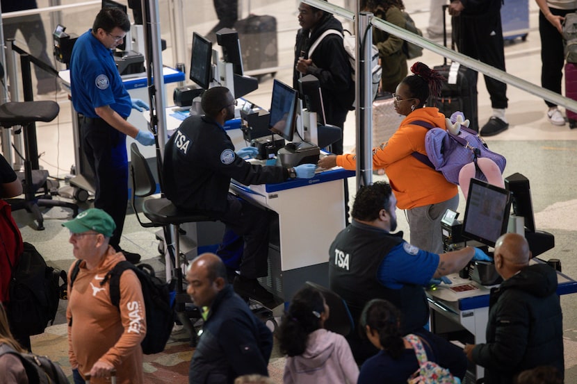 TSA workers check in passengers at the security checkpoint at Dallas Love Field airport in...