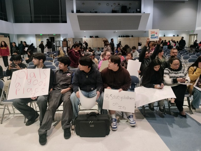 Students from Torres High sit in an auditorium displaying signs