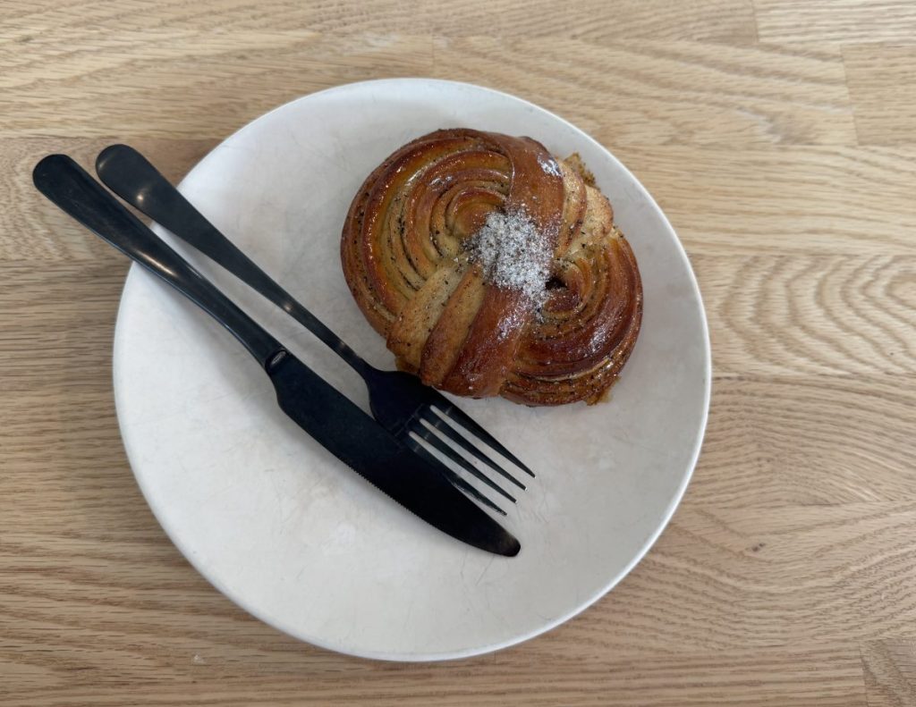 A pastry on a plate with a fork and knife.
