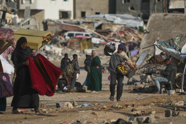 A Palestinian man carries bags of firewood after collecting them from the rubbish in Khan Younis, southern Gaza Strip, on Saturday, Nov. 15, 2025.(AP Photo/Abdel Kareem Hana)