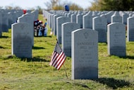 An American flag sits next to a headstone during the 2024 Veterans Day ceremony at...