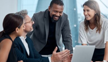 4 people in a corporate setting talking and laughing.