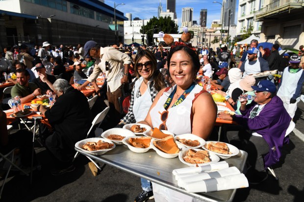 Betty Rodriguez and Gabriela Neufeld help serve food during the...
