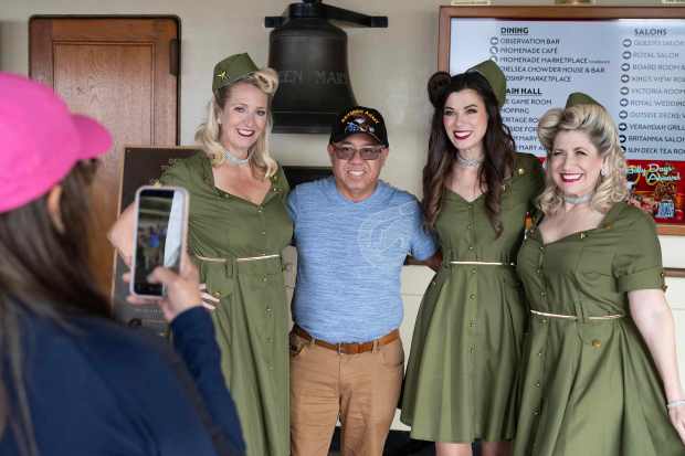 Army Veteran Robert Respicio, center, poses for a photograph with...