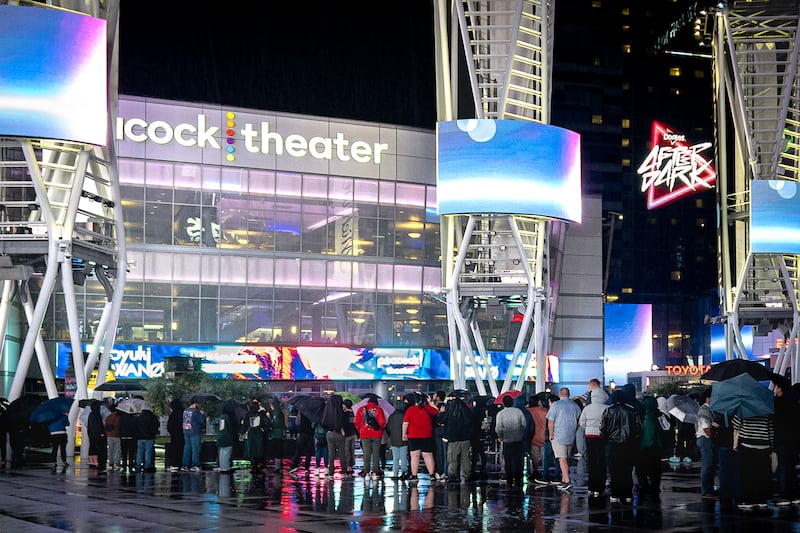 Fans line up in the rain, waiting to get into Peacock Theater.