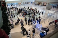 TSA workers check in passengers at the security checkpoint at Dallas Love Field on Friday,...
