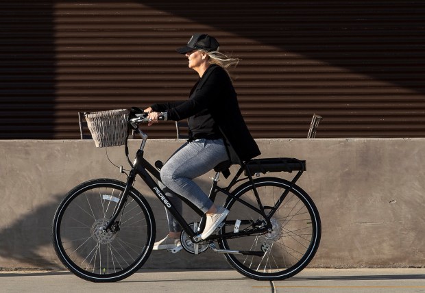A woman rides an electric bike in Newport Beach. (Leonard Ortiz / The Orange County Register)