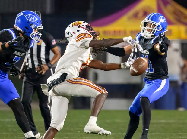 El Modena wide receiver Samuel Jackett, center, can’t hang onto...