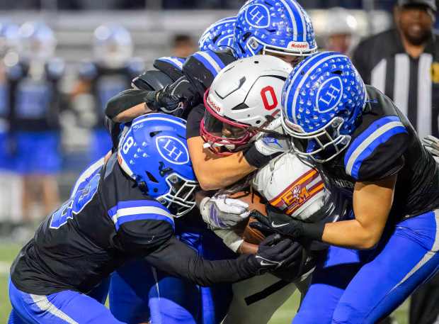 El Modena wide receiver Samuel Jackett is swarmed by La...