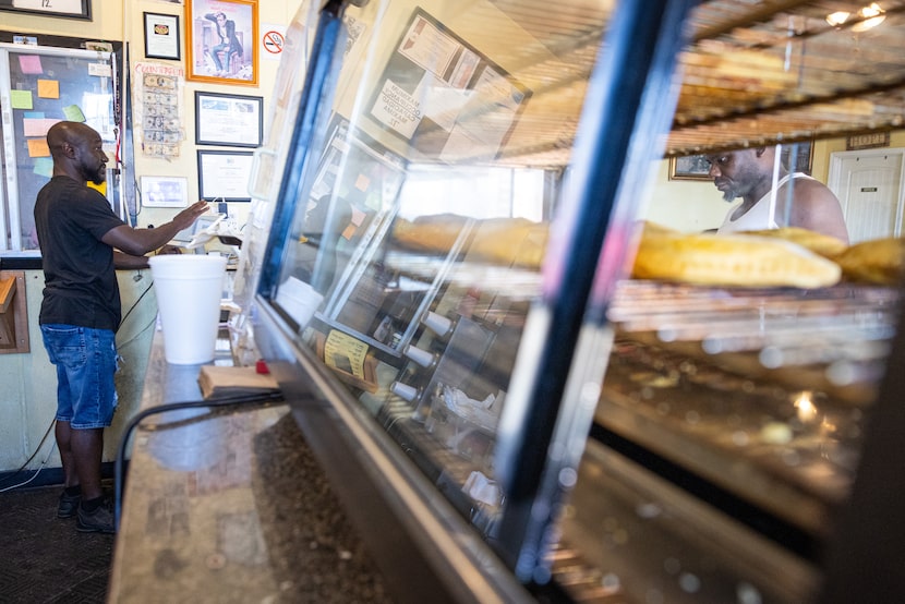 Cedrice Bohanon, right, waits to order food from Matthew Graham, manager at Jamaican cuisine...