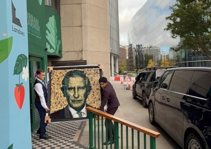 Men carry a portrait of King Charles III by Dallas artist Michael Shellis. The artist...