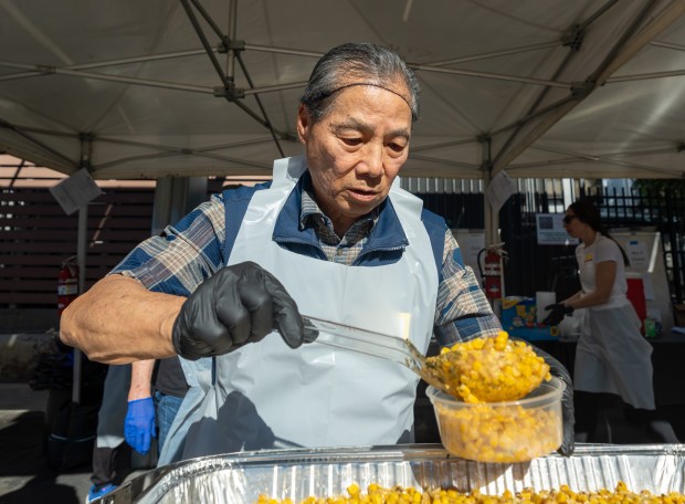 Gene Masuda scooping corn during USHS Adult Center’s Thanksgiving event...