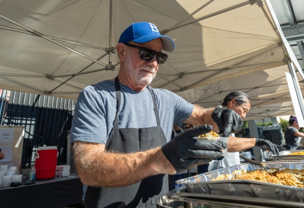 Howard Khan scooping mac & cheese during USHS Adult Center’s...