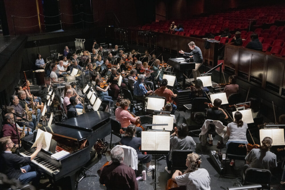 Conductor rehearses with orchestra