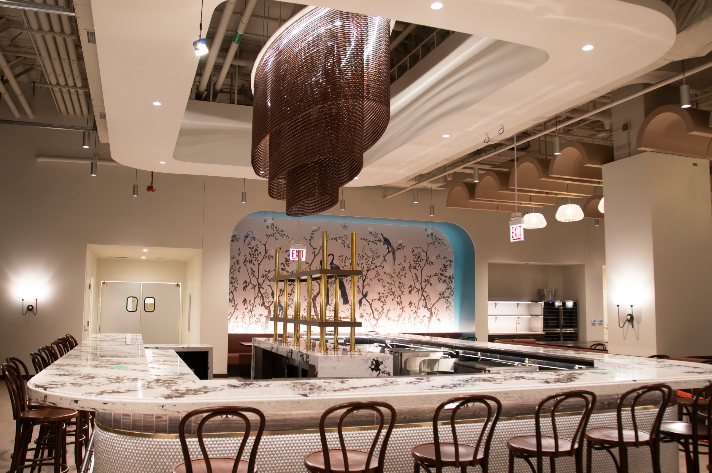 A wraparound bar with a chandelier-like art installation above it.