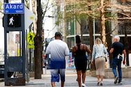 Pedestrians walk along the intersection of Main St. and Akard St. on Tuesday, March 5, 2024...