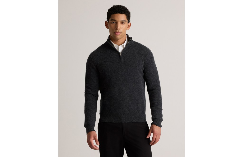 A man in a charcoal half-zip sweater with a white shirt underneath.