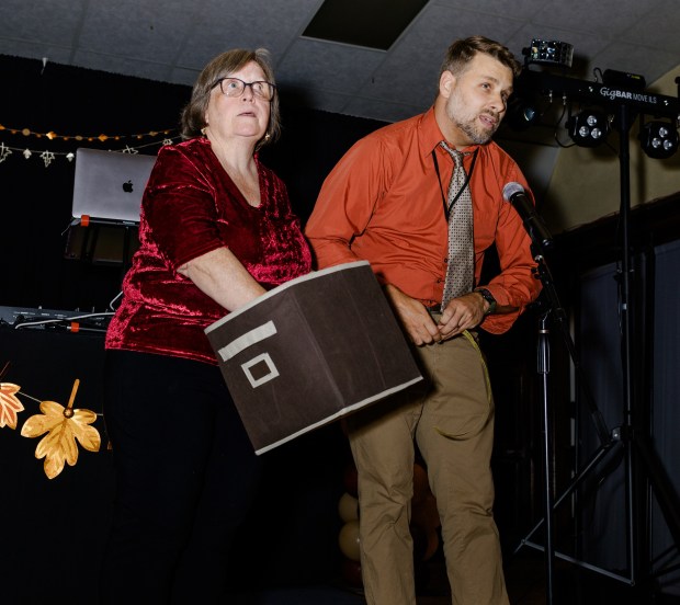 Preschool Director Mary Mancini pulls out gift bundle tickets as...