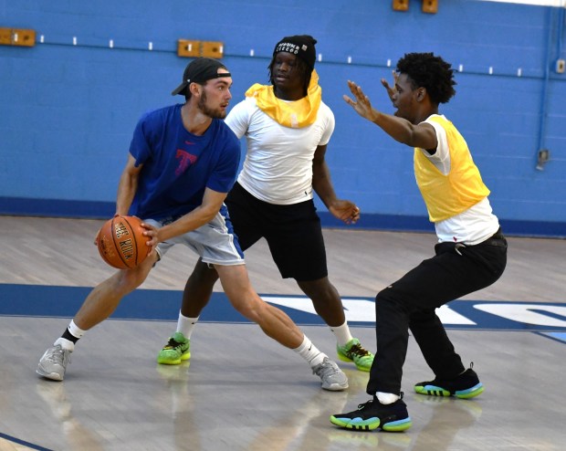 Program volunteer Jackson Treski gets double teamed by Zaid McDonald and Jameer Bellinger. (Photo by Rick Cawley)