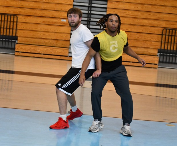 Program volunteer Ben Schlosser jostles with Ryan Terrell for rebounding...