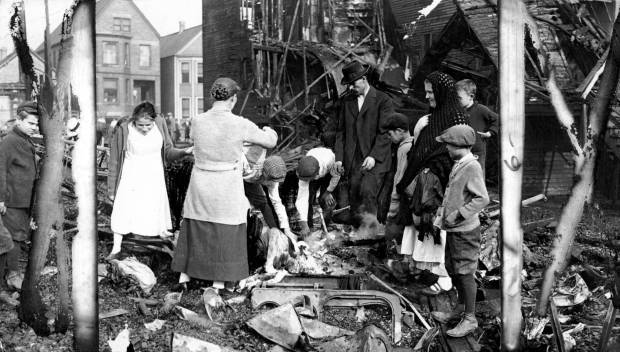 People look over the remains of a destroyed building in...