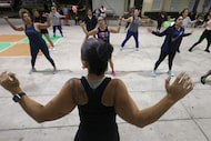 Zumba instructor Maribel DelCampo, foreground, guides class participants through a series of...