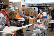 Rob Dolby, senior director of community partner relations at North Texas Food Bank, hands...