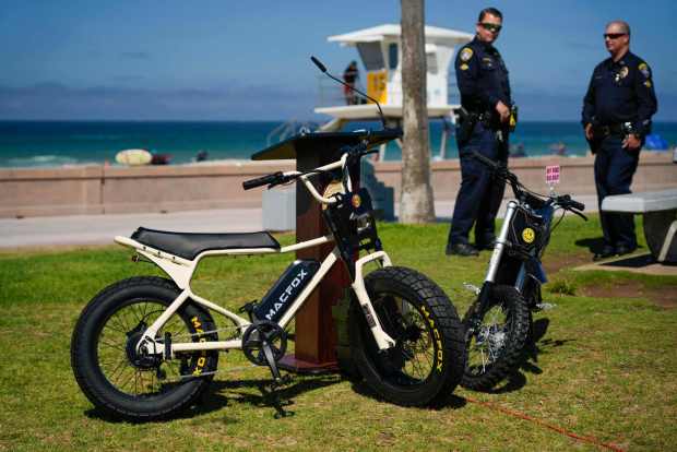 An e-bike is displayed next to an e-motorcycle as law enforcement agencies and health care professionals from across San Diego County held a news conference Sept. 8 on the need for safe ridership. (Alejandro Tamayo / The San Diego Union-Tribune)