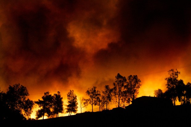 File photo from Oct. 21, 2007, on the first day of the Harris fire and not far from Dulzura, the night glows from the flames. (Nelvin C. Cepeda / The San Diego Union-Tribune)