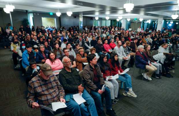 Vista, CA - At Vista City Hall a capacity crowd fills the darkened Community Room as they watch and listen to live video of the adjacent City Council meeting where the Council will vote on the Community Safety and Due Process Resolution. Prior to the Council meeting there was a community rally in support of the resolution. (Charlie Neuman / For The San Diego Union-Tribune