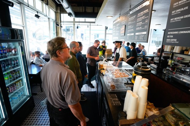 During the start of the lunch hour at Grab & Go Sub on First and C streets in downtown San Diego, owner Christian Arce takes orders from customers on Oct. 1.  (Nelvin C. Cepeda / The San Diego Union-Tribune)