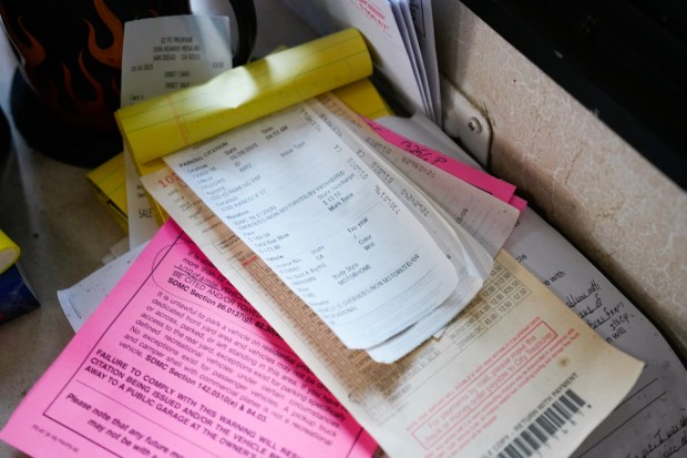Kevin Denczek, 67, has several parking citations on the tabletop of his RV home. (Nelvin C. Cepeda / The San Diego Union-Tribune)