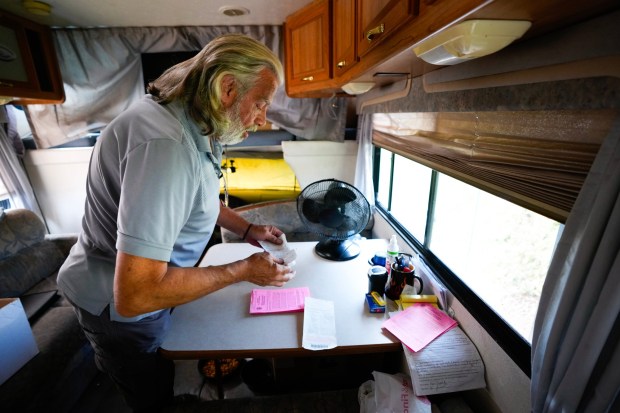 Kevin Denczek, 67, sorts through his paperwork looking for past parking citations. (Nelvin C. Cepeda / The San Diego Union-Tribune)
