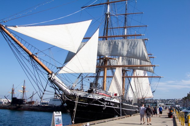 People walk along the Embarcadero to take a closer look at the Star of India. (Brittany Cruz-Fejeran / The San Diego Union-Tribune)