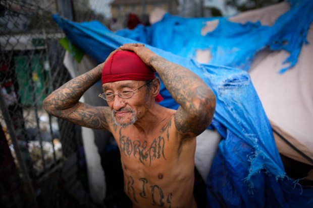 Andrew Shields, 56, expresses his frustration after receiving a 72-hour notice to remove his belongings and makeshift shelter at the encampment near the I-5 freeway on Tuesday.  Shields says for the past 6-weeks he has asked officers from the San Diego Police Department for shelter but was told there was no room. (Nelvin C. Cepeda / The San Diego Union-Tribune)