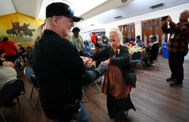 James Fotis, a staff member with We See You San Diego, dances with Lori Nordsden during this week's weekly dinner at Immaculate Conception Catholic Church on Tuesday, Nov. 25, 2025, in San Diego, CA.  Nordsden, who recently relocated to San Diego from New Mexico, is living out of her car. (Nelvin C. Cepeda / The San Diego Union-Tribune)