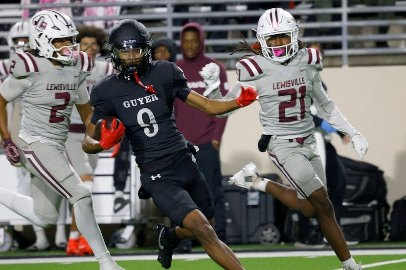 Denton Guyer's Tristan Shelton (9) carries the ball as Lewisville's Deuce Mathis (2) and...
