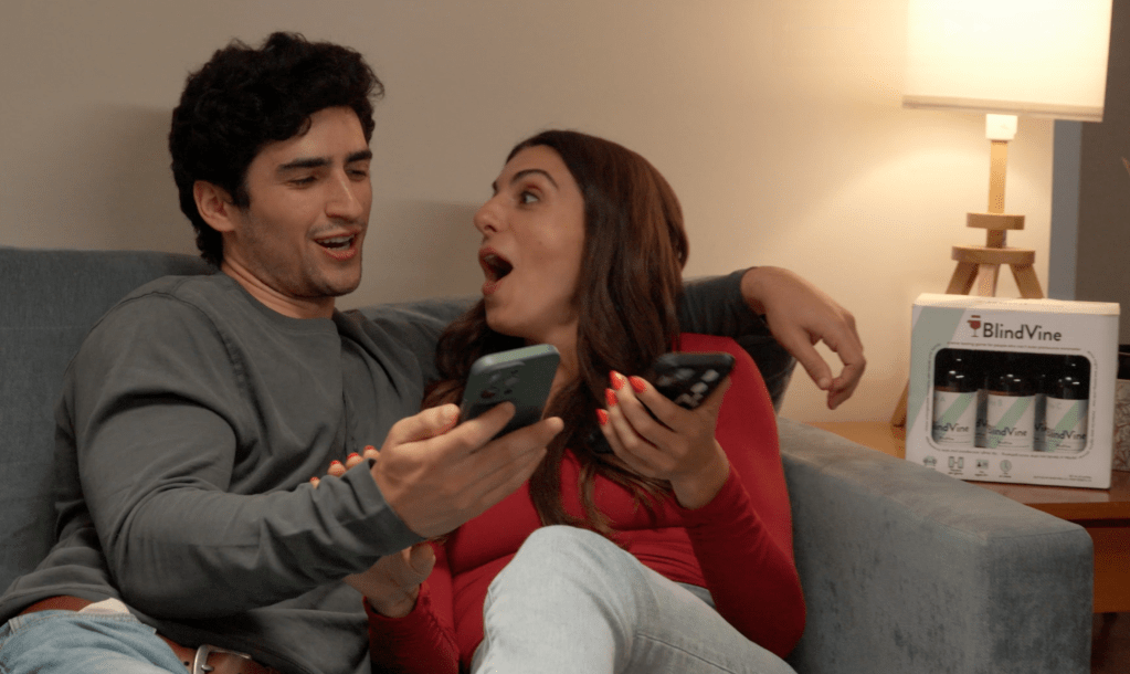 a couple on a couch looking at their phone