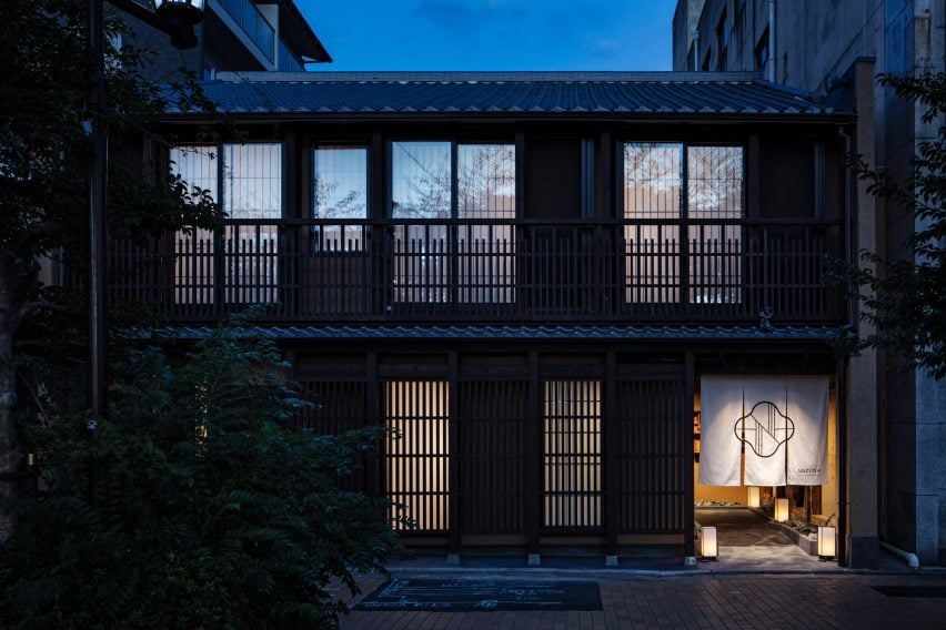 An image from the outside of the building shows latticed washi-paper windows, with an open entrance to the bottom right corner of the property. Over the entrance hangs a white sheet.