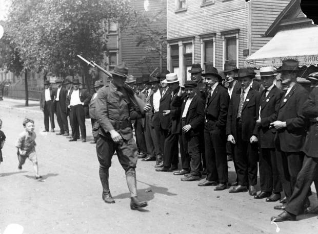 A soldier walks past a group of men during the...