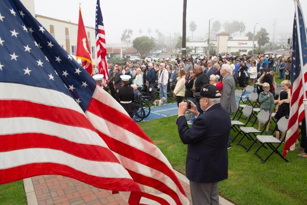 A crowd of veterans, family members and local residents stand...