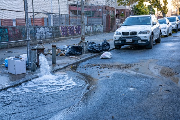 A major water main break broke up the roadway in...