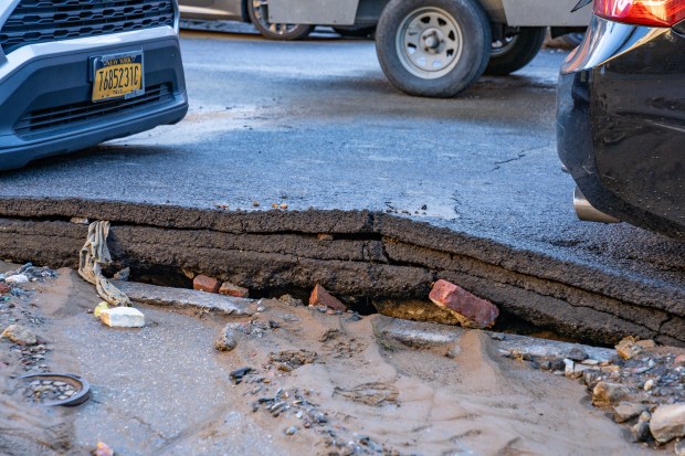 A major water main break broke up the roadway in...