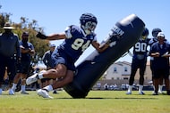 Dallas Cowboys defensive end Marshawn Kneeland (94) turns the corner on a blocking dummy...