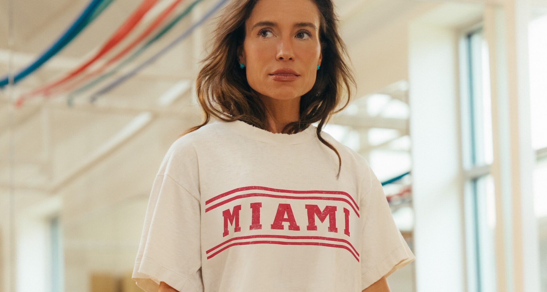 headshot photo of fitness entrepreneur Tracy Anderson in her studio wearing a white t-shirt with red lettering reading, "Miami"