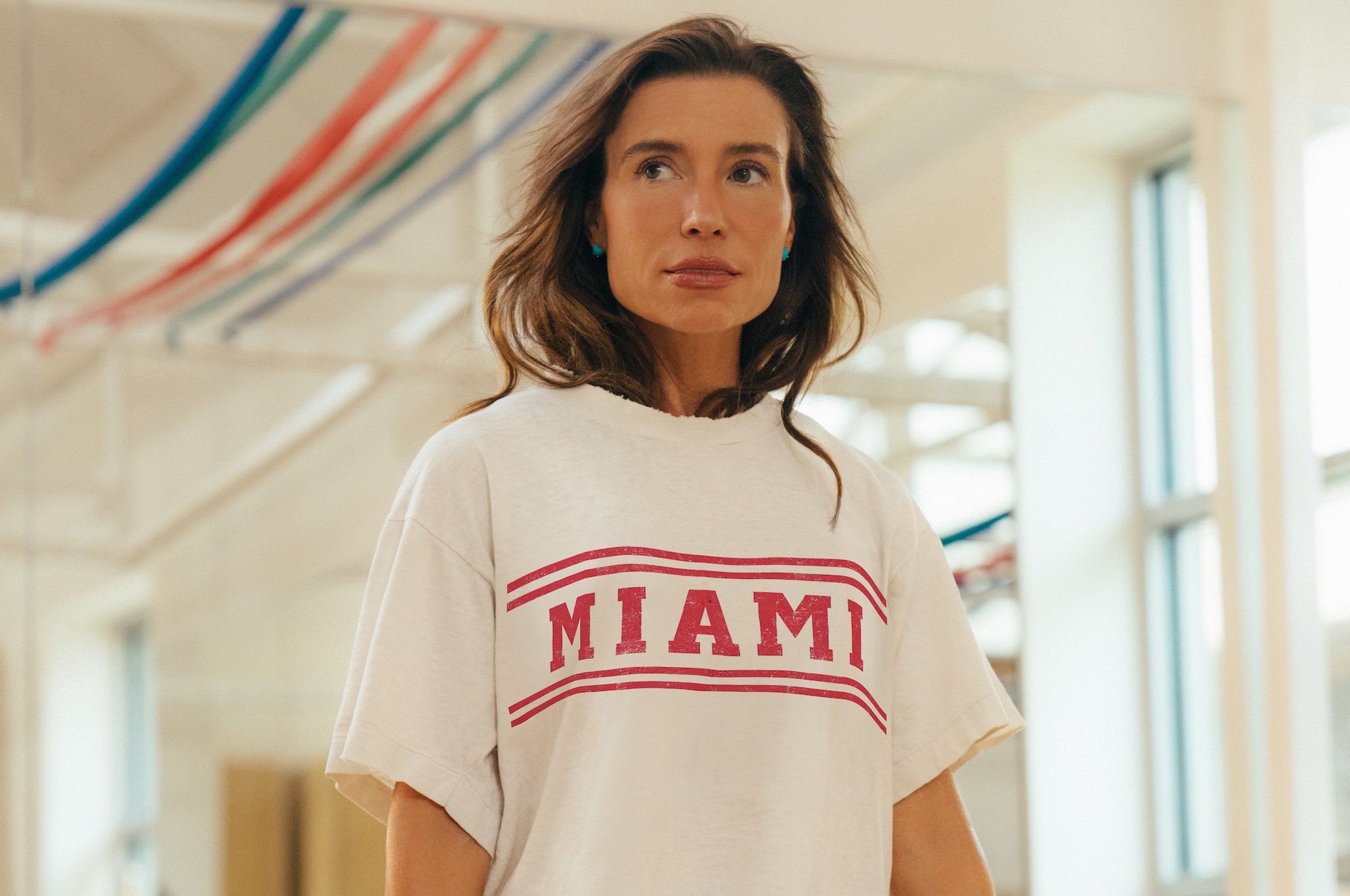 headshot photo of fitness entrepreneur Tracy Anderson in her studio wearing a white t-shirt with red lettering reading, "Miami"