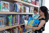 Dana Centeno shows a book to her eighth-month-old son Nicholas in Vickery Meadow Library on...