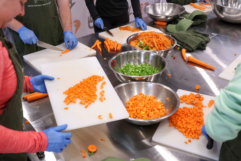 Volunteers chop carrots and bell peppers for Our Giving Kitchen on Sunday, Nov. 2, 2025, in...